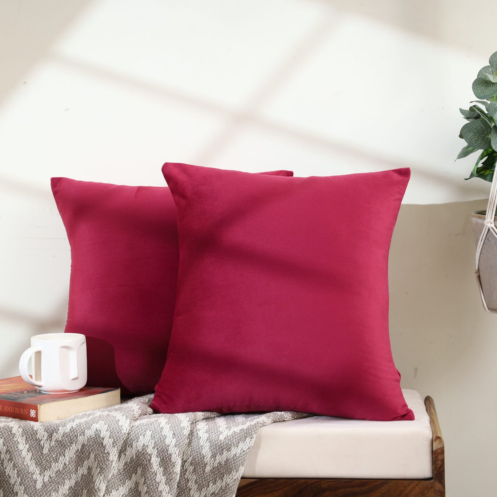 Creative photography of a maroon cushion with a sun shadow in Jaipur, highlighting the interplay of light and texture