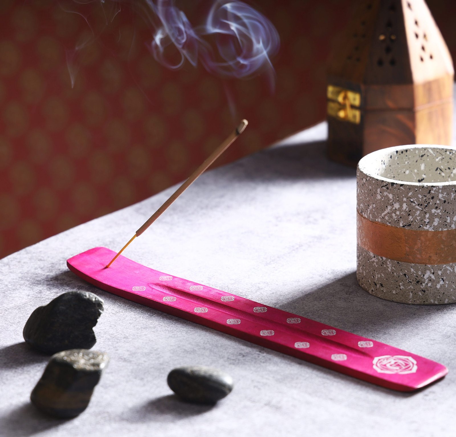 Product photography of an incense burner placed on a wooden bottom sheet, surrounded by delicate flowers