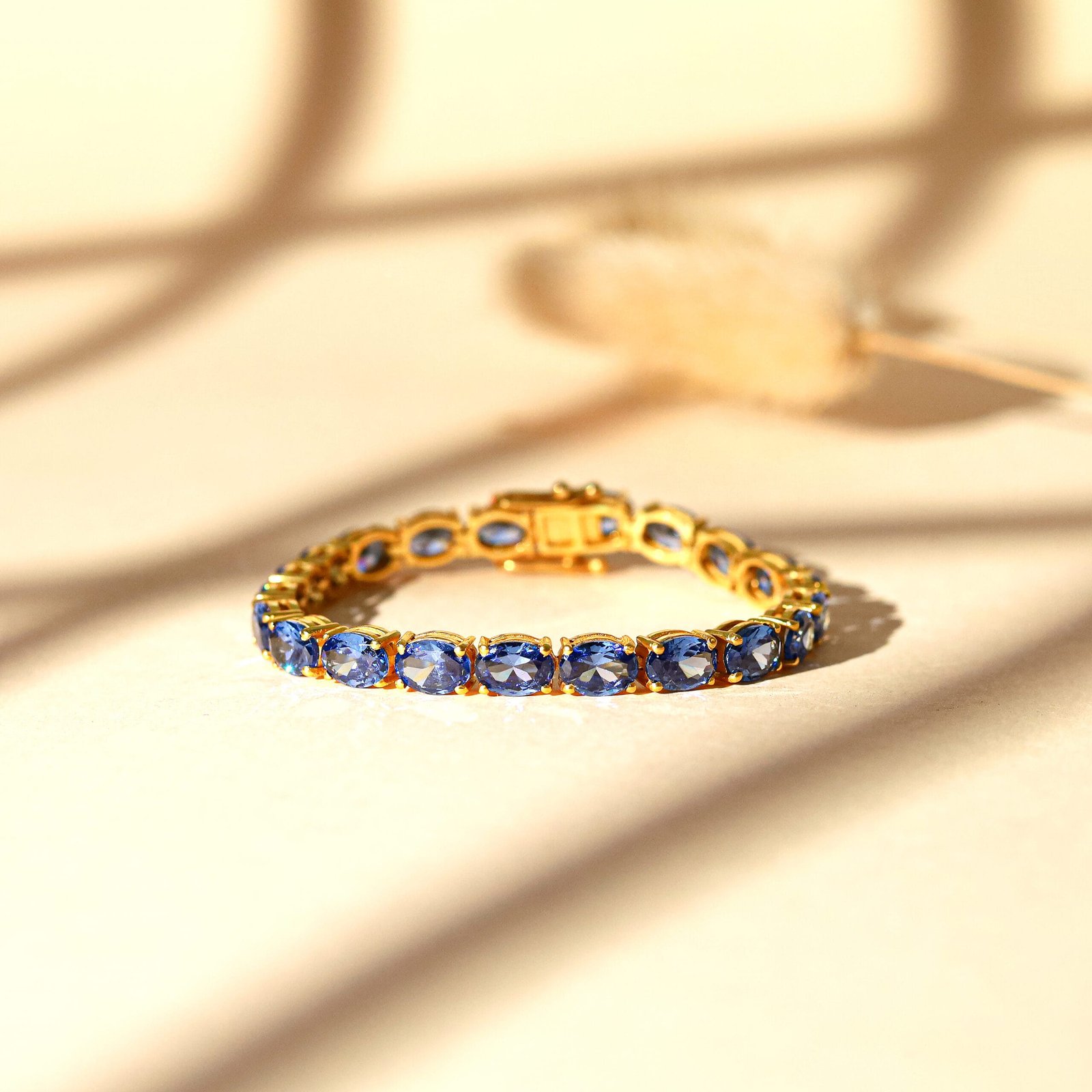 Close-up jewelry photography of a gold bracelet with a blue stone in Jaipur, showcasing its intricate design