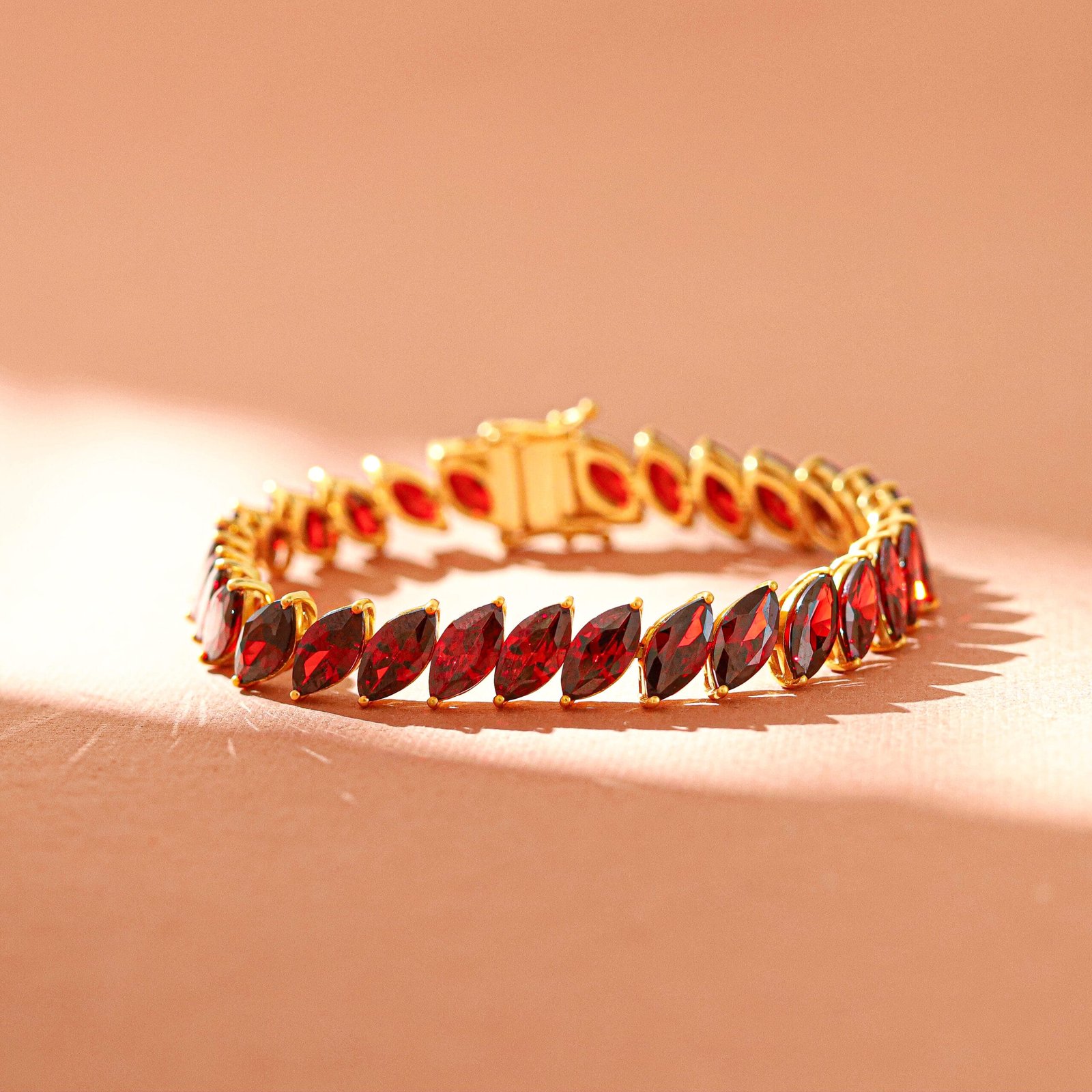 Artistic product photography of a gold bracelet featuring a red gemstone in Jaipur, emphasizing its luxurious appeal